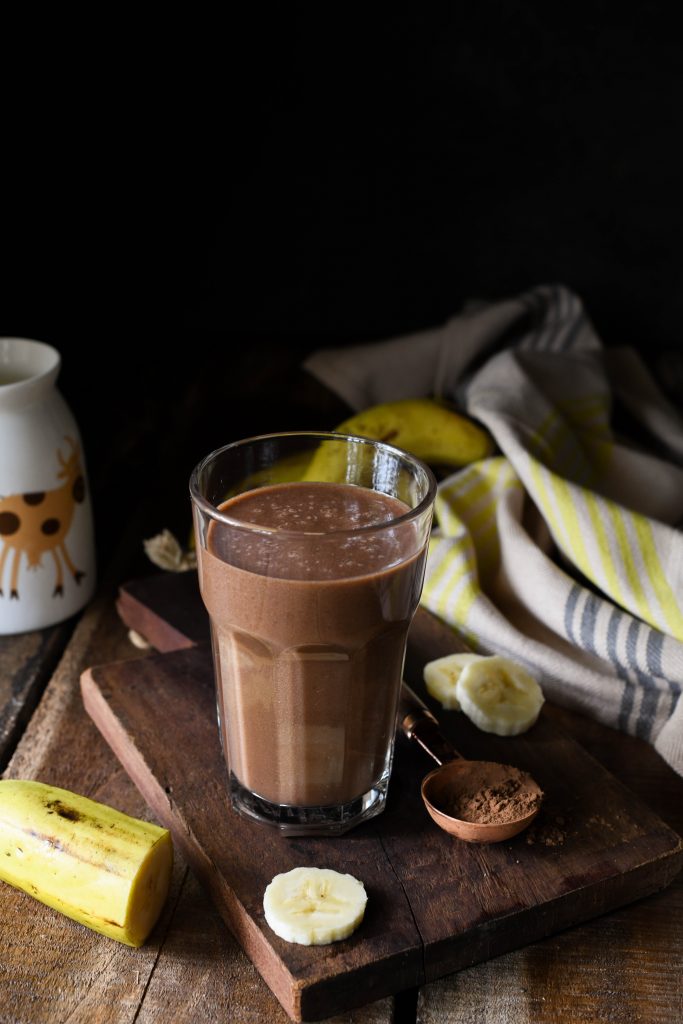 Chocolate banana smoothie with sliced banana, cocoa powder and milk